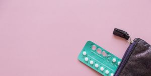 High Angle View Contraceptive Pill And Purse Over Pink Background