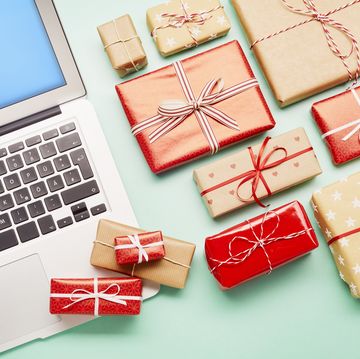 high angle view of a laptop computer and gifts on turquoise background, online shopping
