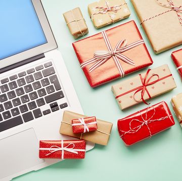 high angle view of a laptop computer and gifts on turquoise background, online shopping