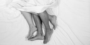 high angle view of barefoot couple relaxing on bed