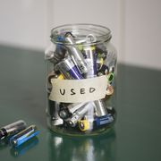 high angle view of batteries in glass jar with used label on table