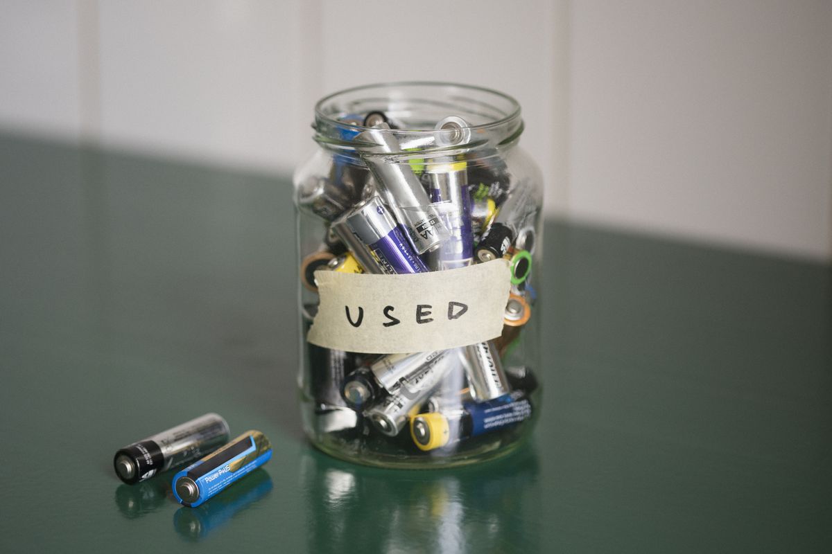 high angle view of batteries in glass jar with used label on table