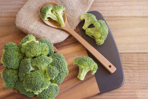 High Angle View Of Broccoli With Spoon And Burlap On Cutting Board At Table