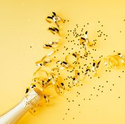 high angle view of champagne with confetti on yellow background