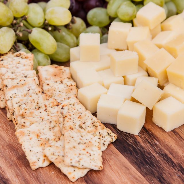 High Angle View Of Cheese With Crackers And Fruits On Table