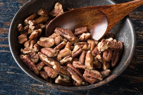 High Angle View Of Chopped Pecans In Bowl On Wooden Table