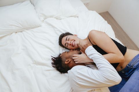 high angle view of couple romancing while lying on bed