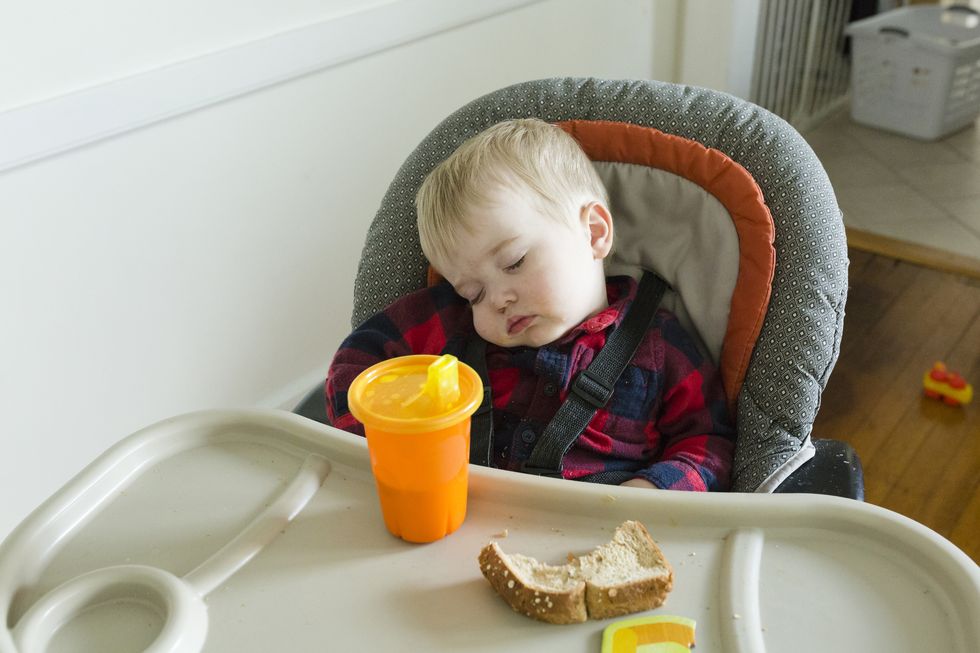el mejor momento para iniciar la alimentación complementaria del bebé a partir de los seis meses es cuando no está cansado para que no ocurra como al bebé de la foto dormido en la trona