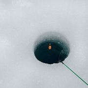 high angle view of fishing rod over hole in frozen lake