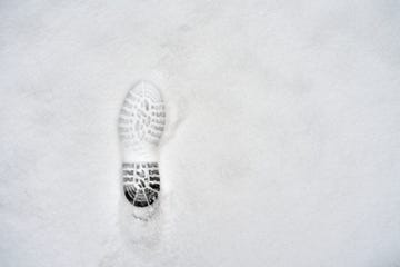 high angle view of footprint of a left boot on fresh snow