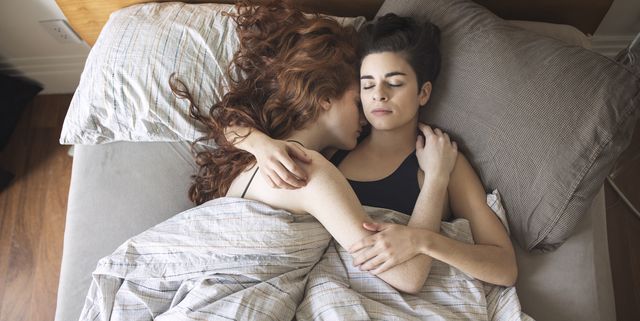 High angle view of lesbian couple sleeping on bed at home