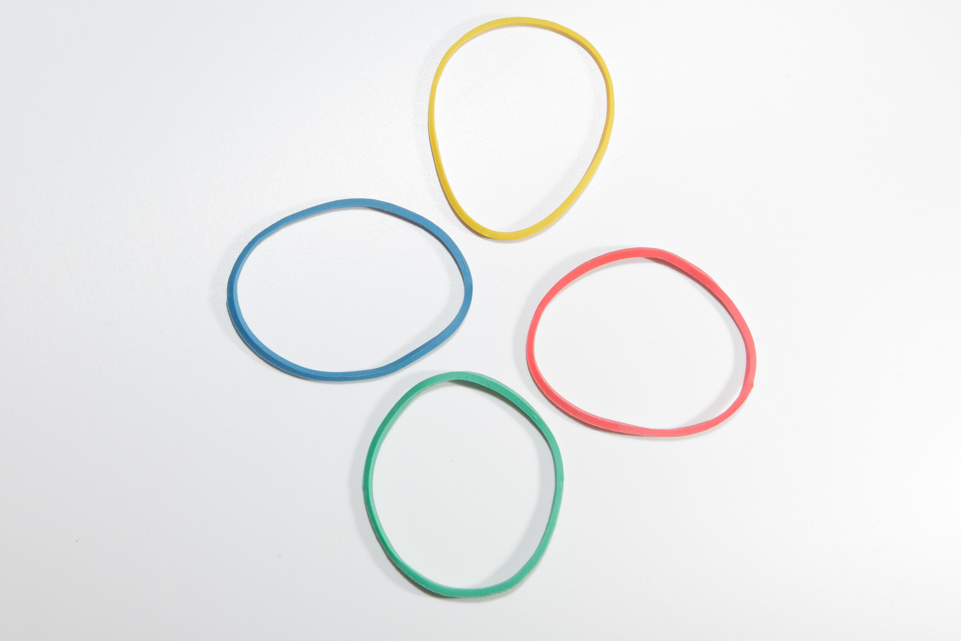 high angle view of multi colored rubber bands over white background