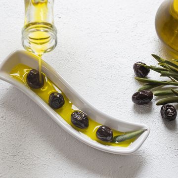 high angle view of olives with olive oil in dish on table