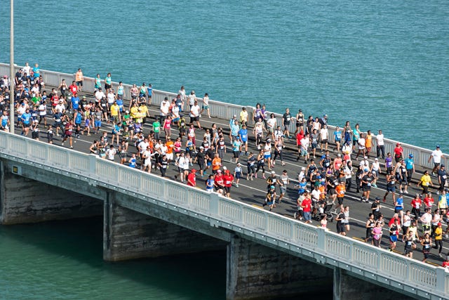 High Angle View Of People Running On Bridge Over Sea