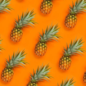 High Angle View Of Pineapples Arranged On Orange Background