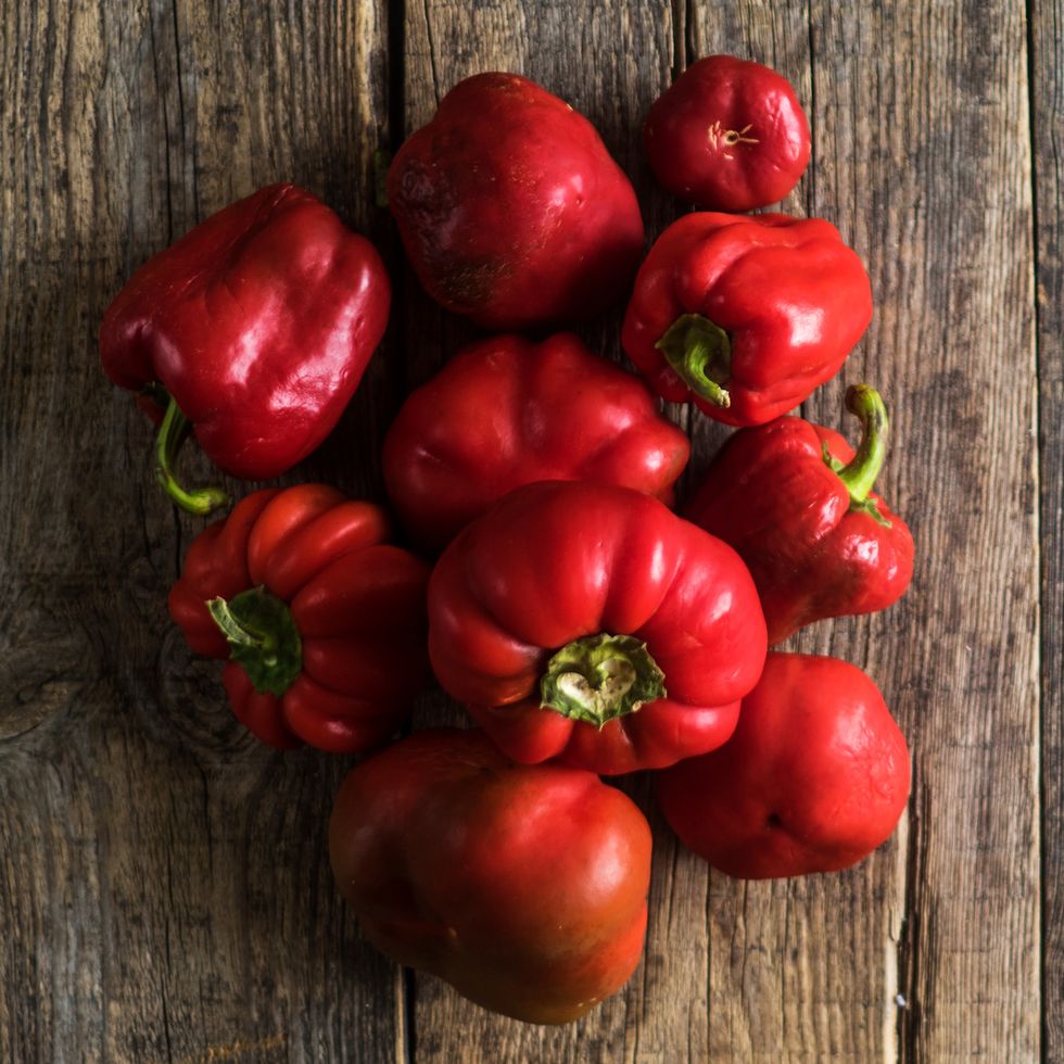 High Angle View Of Red Bell Peppers On Wooden Table
