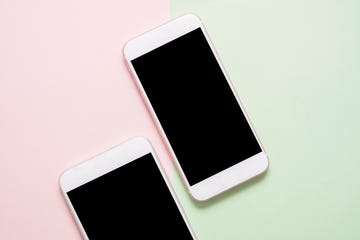 High Angle View Of Smart Phones On Colored Background