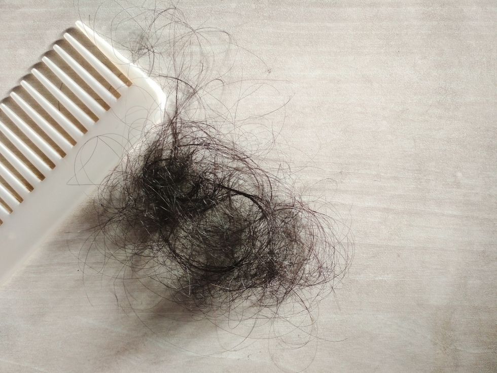 high angle view of tangled hair by comb on table