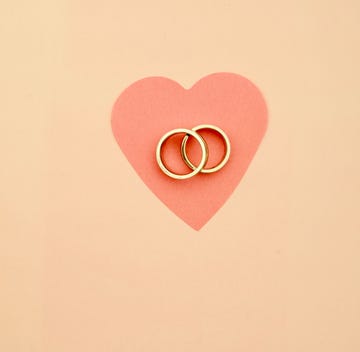 High Angle View Of Wedding Rings And Heart Shape Paper On Table