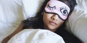 High Angle View Of Woman Wearing Eye Mask While Sleeping In Bed