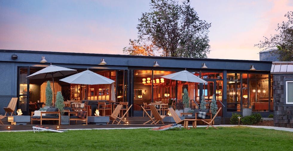 outside area at high country motor lodge filled with firepits and wooden adirondack chairs