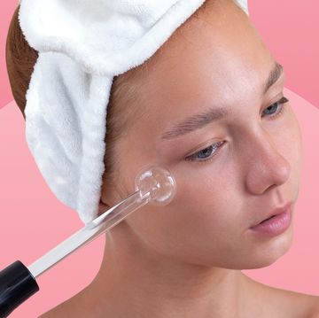 woman using high frequency wand on cheek