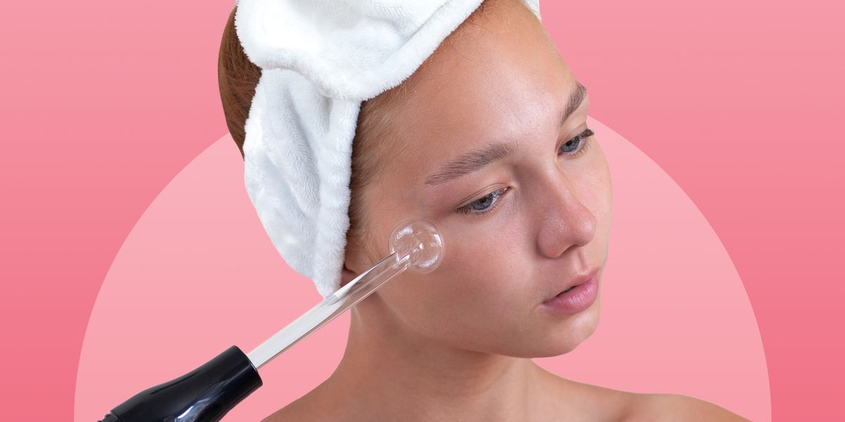 woman using high frequency wand on cheek