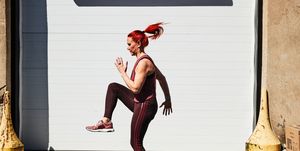 a woman in a tank top and red hair working out