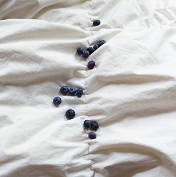a group of blue berries on a white surface