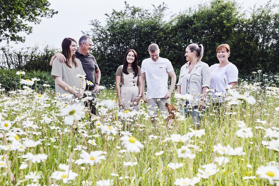 the robertson family standing in a wildflower meadow at higher oak farm