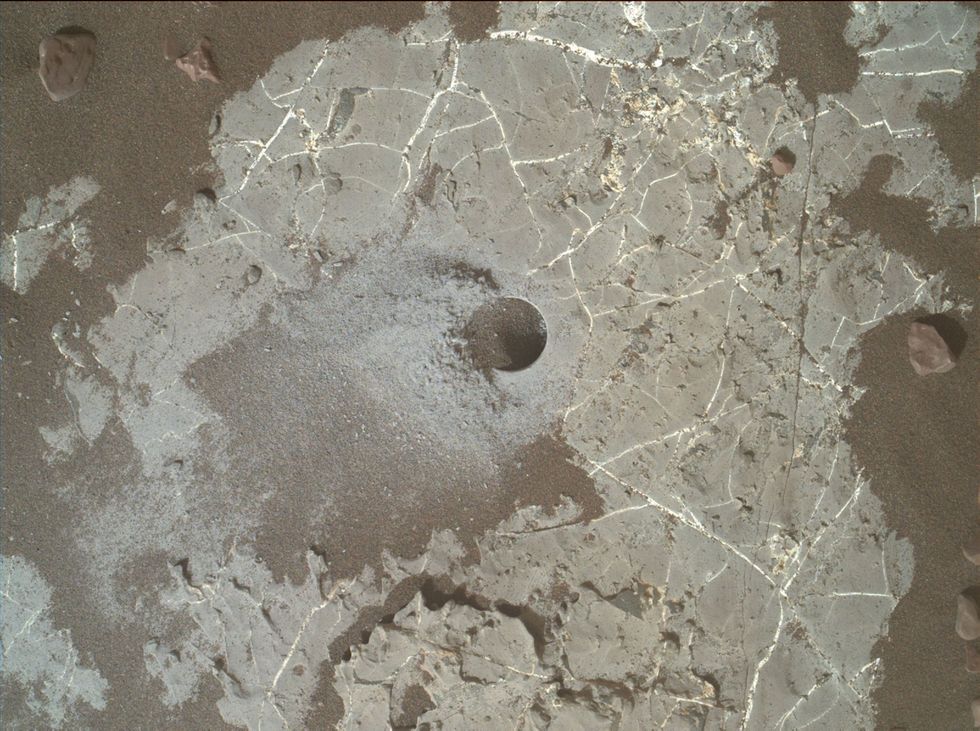 Op deze foto is een gat te zien dat door de rover Curiosity werd uitgeboord in een rots op de Martiaanse onderzoekslocatie Highfield op de Vera Rubin Ridge binnen de Galekrater In het boorgruis uit het gat vond Curiosity een verhoogd gehalte aan lichte koolstofisotopen wat kan wijzen op de aanwezigheid van levensvormen op Mars