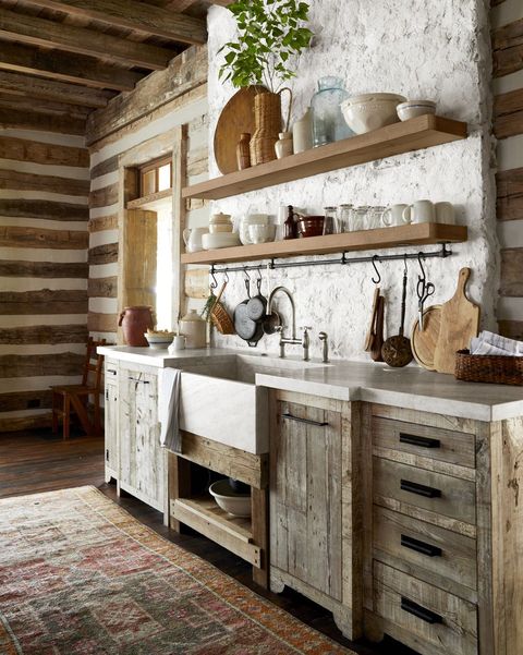 angled view into a back kitchen sink area in a rustic mountain house open shelving hold a mix of pottery and glass