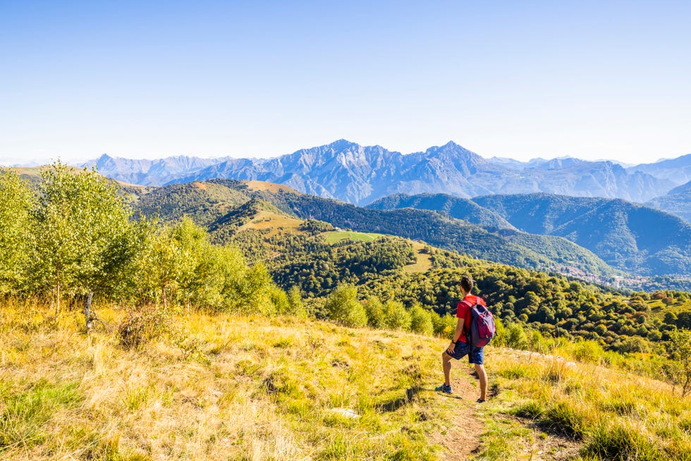 hiker admiring the view of grigne from palanzone mount, sormano, como province,lombardy, italy