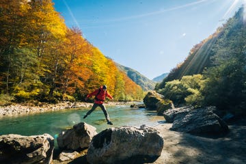 hiker relaxes near autumnal river