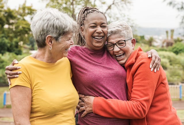 happy multiracial senior women having fun together outdoor elderly generation people hugging each other at park