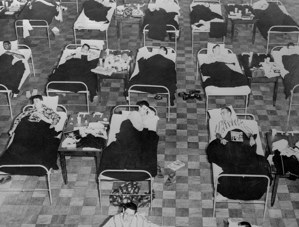 Studenten die in 1957 ziek waren geraakt door de Aziatische griep liggen in een tijdelijk onderkomen in het gebouw van de studentenvereniging van de University of Massachusetts In de Verenigde Staten stierven ruim honderdduizend mensen aan het virus