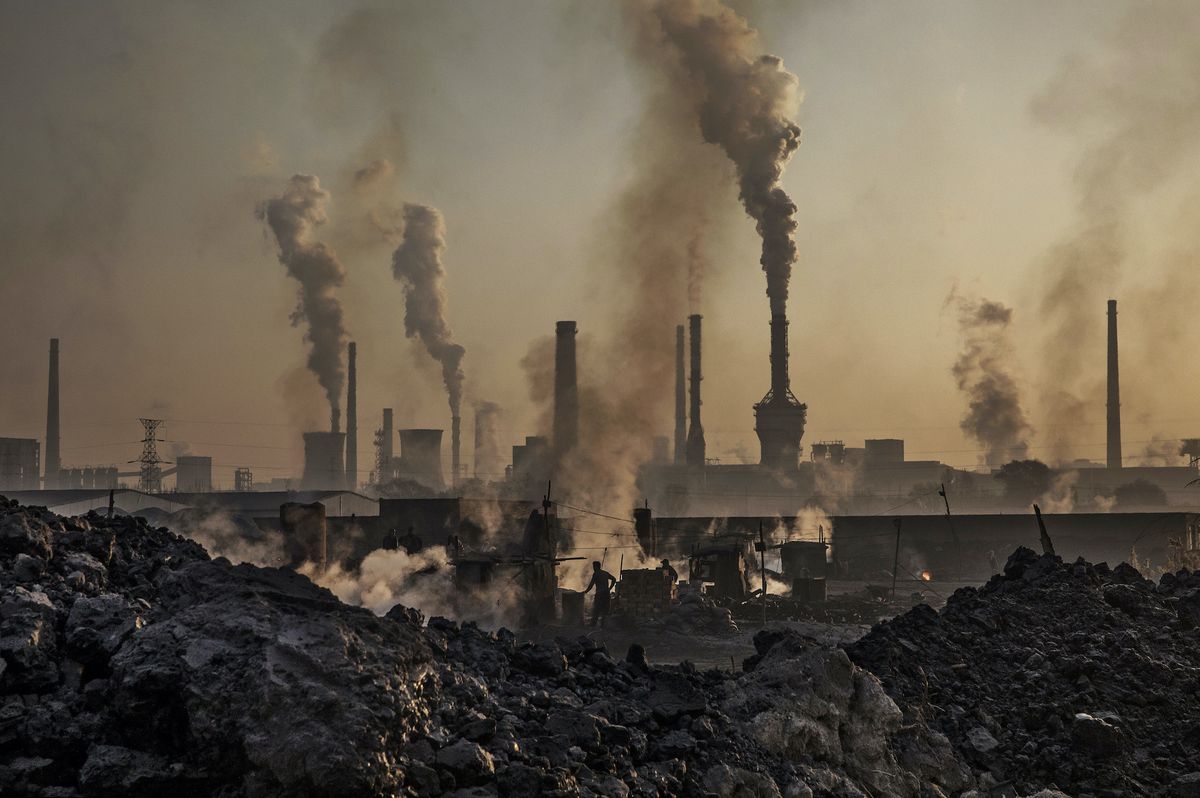 inner mongolia, china   november 04 smoke billows from a large steel plant as a chinese labourer works at an unauthorized steel factory, foreground, on november 4, 2016 in inner mongolia, china to meet china's targets to slash emissions of carbon dioxide, authorities are pushing to shut down privately owned steel, coal, and other high polluting factories scattered across rural areas in many cases, factory owners say they pay informal 'fines' to local inspectors and then re open the enforcement comes as the future of us support for the 2015 paris agreement is in question, leaving china poised as an unlikely leader in the international effort against climate change us president elect donald trump has sent mixed signals about whether he will withdraw the us from commitments to curb greenhouse gases that, according to scientists, are causing the earth's temperature to rise trump once declared that the concept of global warming was "created" by china in order to hurt us manufacturing china's leadership has stated that any change in us climate policy will not affect its commitment to implement the climate action plan while the world's biggest polluter, china is also a global leader in establishing renewable energy sources such as wind and solar power photo by kevin frayergetty images