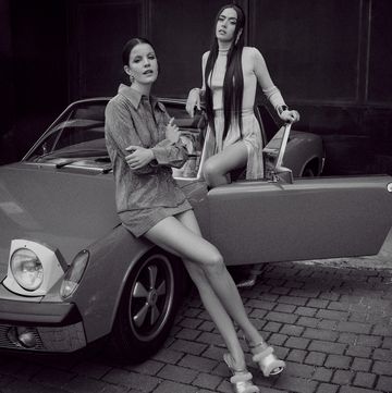 two women sitting on a car