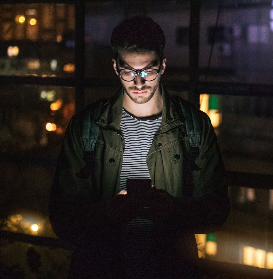 hipster in the night using a mobile phone
