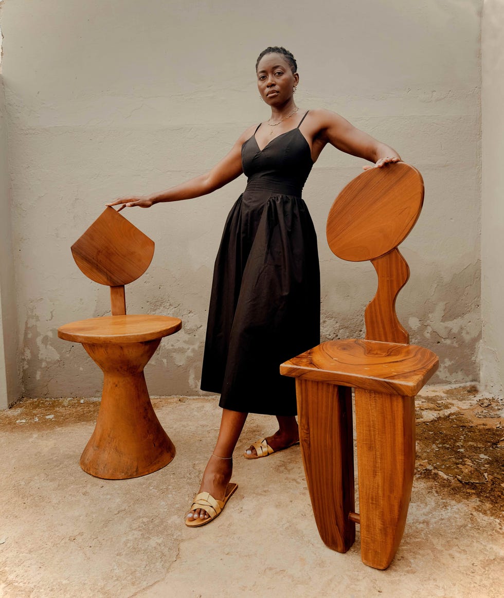 a woman standing in between two wooden stools