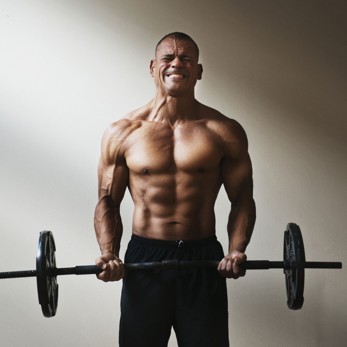 Hispanic athlete lifting weights