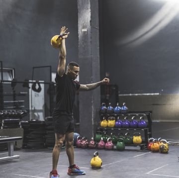 hispanic man lifting kettlebell in a gym