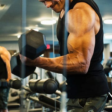 hispanic man weightlifting in gymnasium