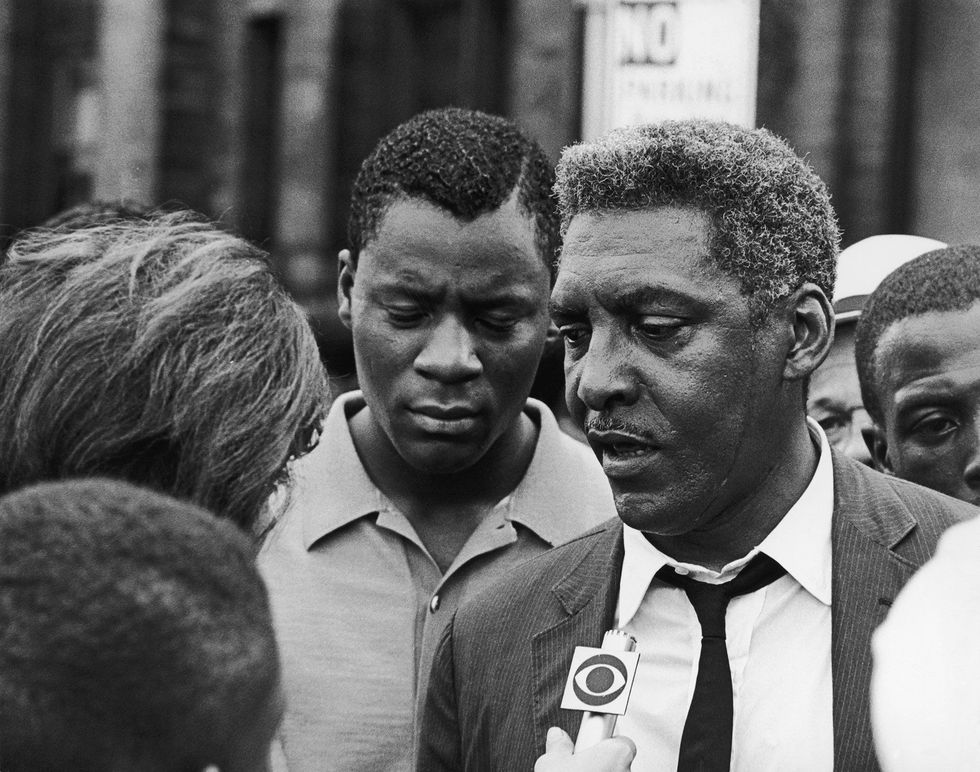 De zwarte burgerrechtenactivist Bayard Rustin praat met verslaggevers tijdens de rellen van 23 juli 1964 in Harlem