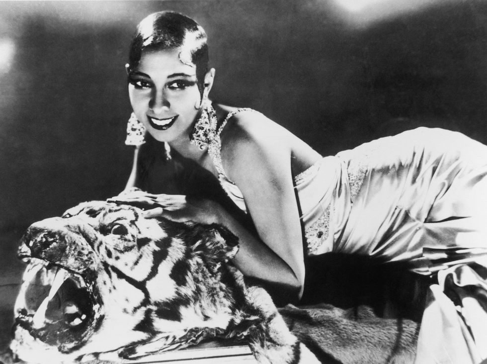 Op deze promotiefoto uit de jaren twintig van de vorige eeuw strekt de zangeres en danseres Josephine Baker  in een zijden nachtjapon en met diamanten oorbellen  zich uit op een tijgervel