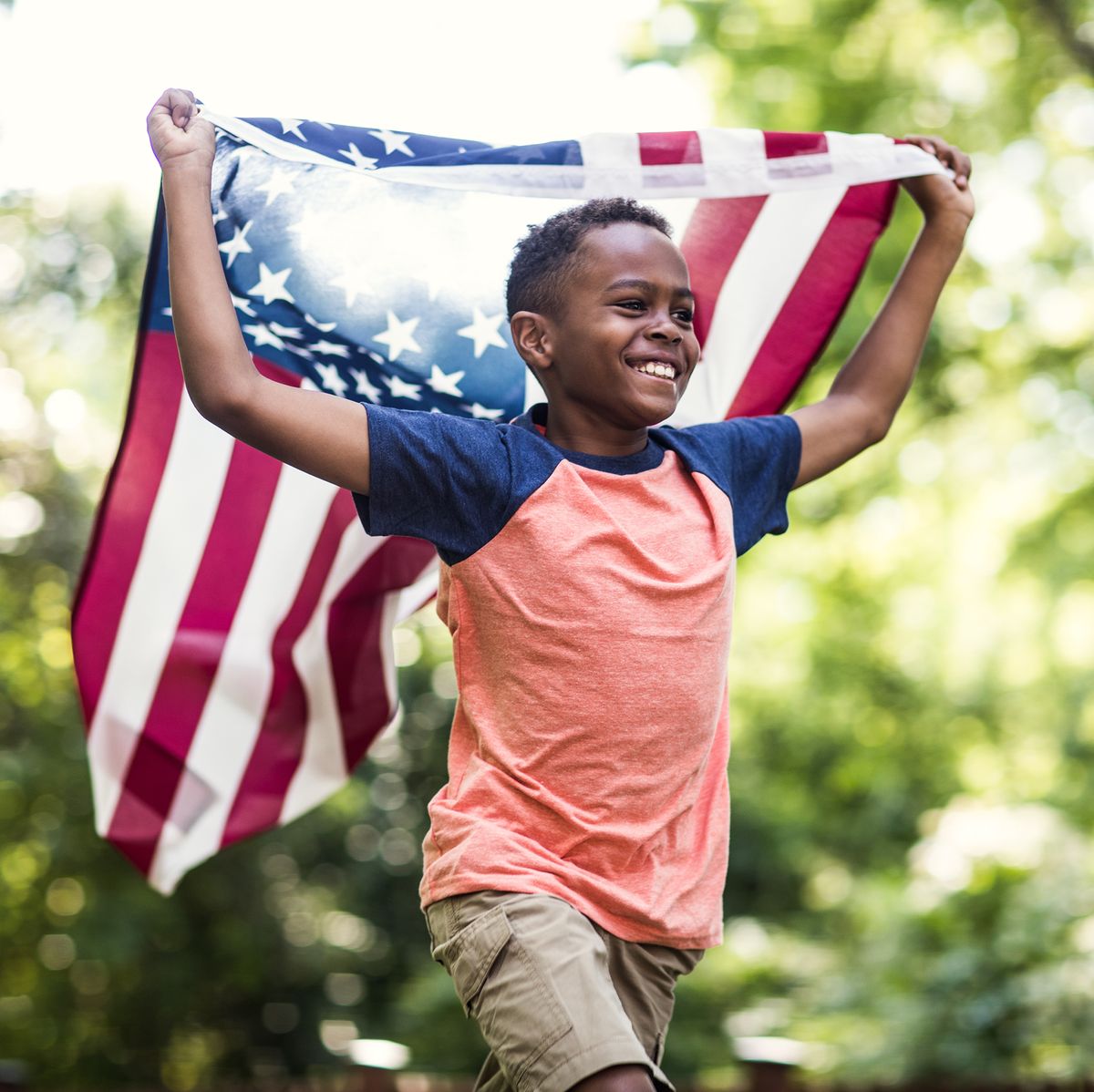 young boy running with american flag