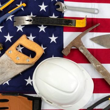 directly above shot of work tools and hardhat on american flag