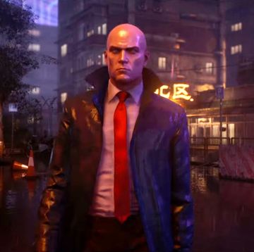 hitman 3, agent 47 walks through a rainy neon city