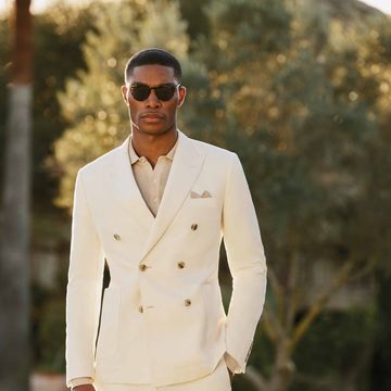 a man wearing a white suit and sunglasses