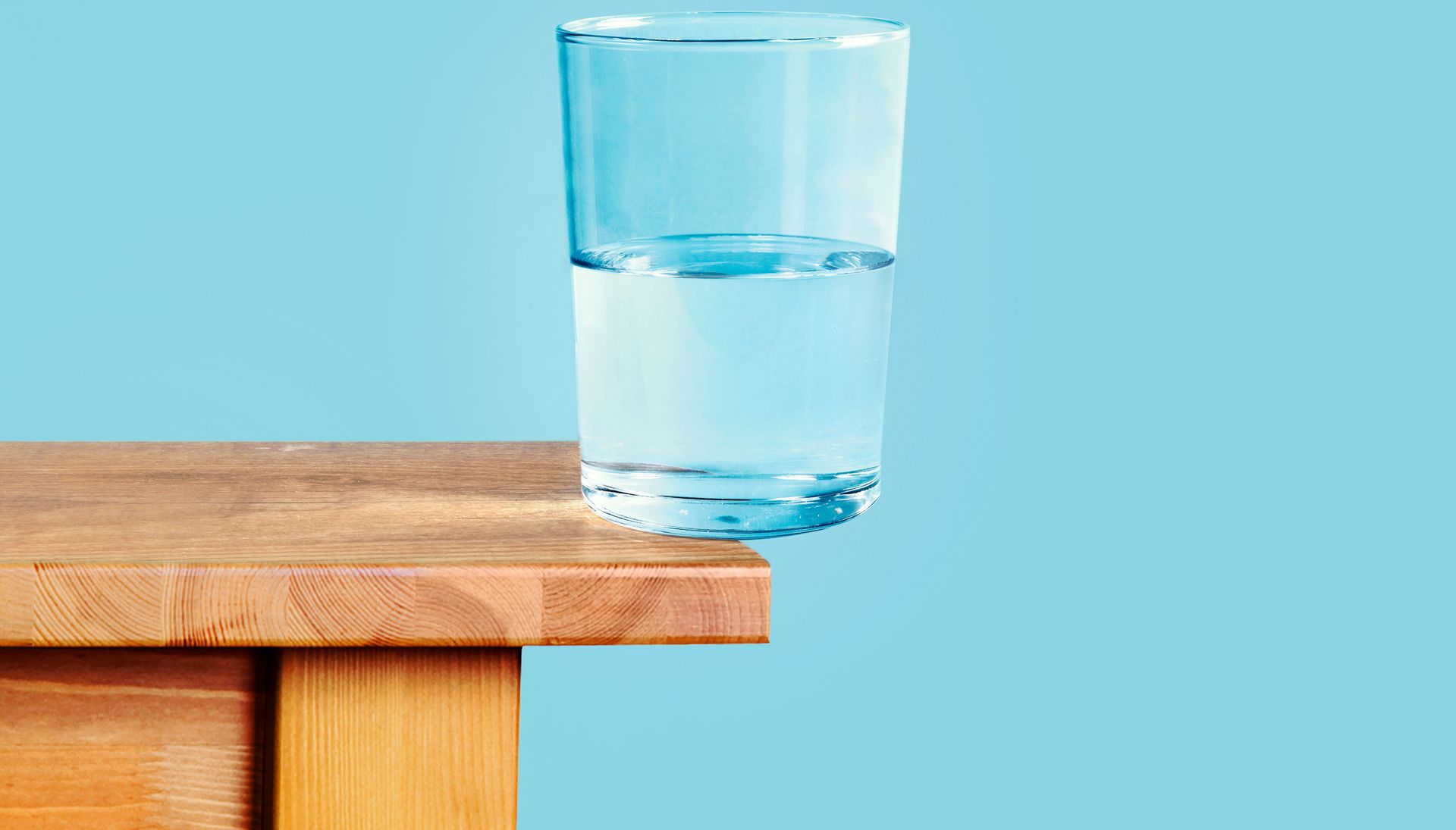 glass of water half full and half on the edge of a table